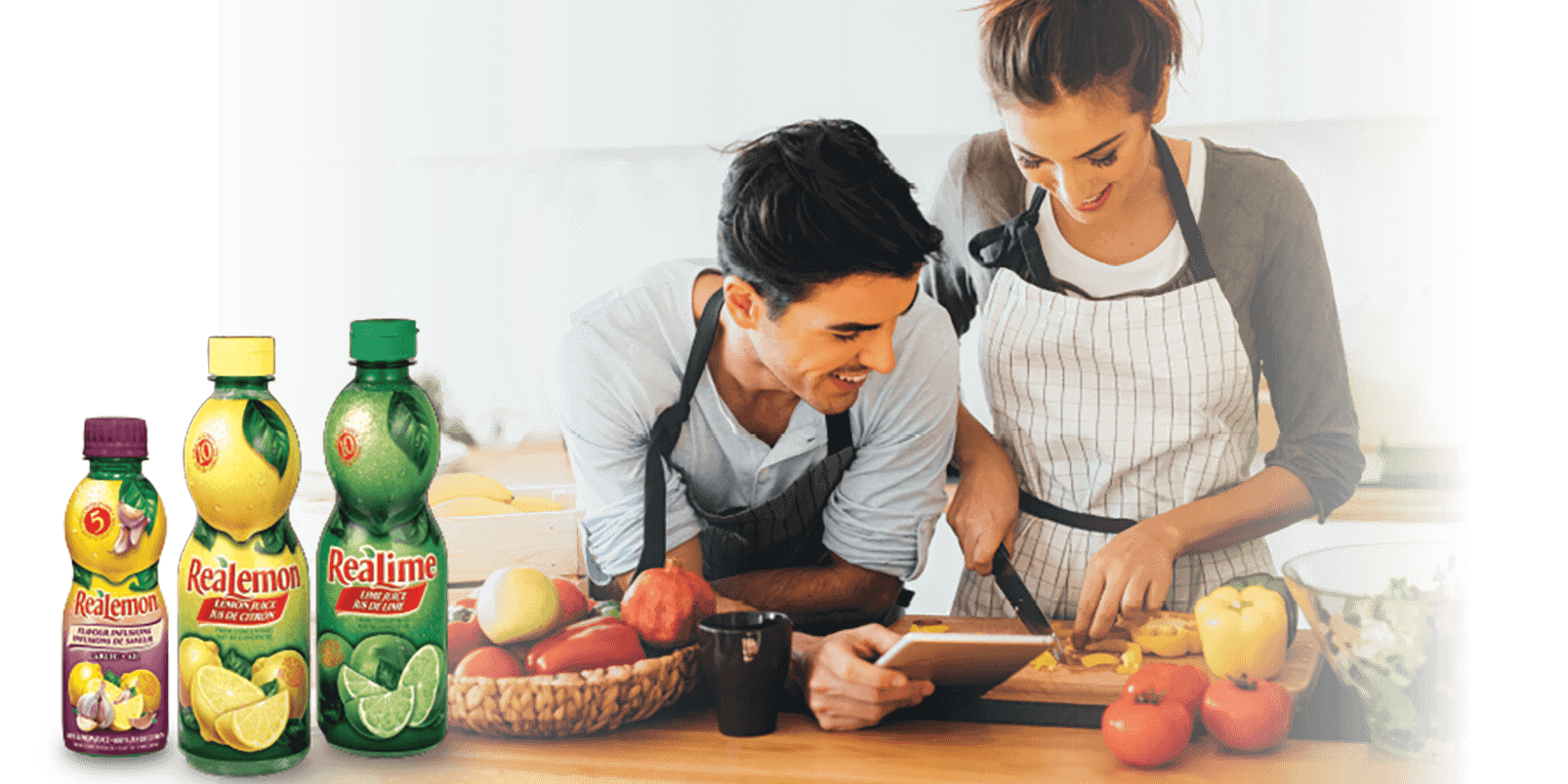 Une femme et un homme cuisinant avec du ReaLemon et du ReaLime