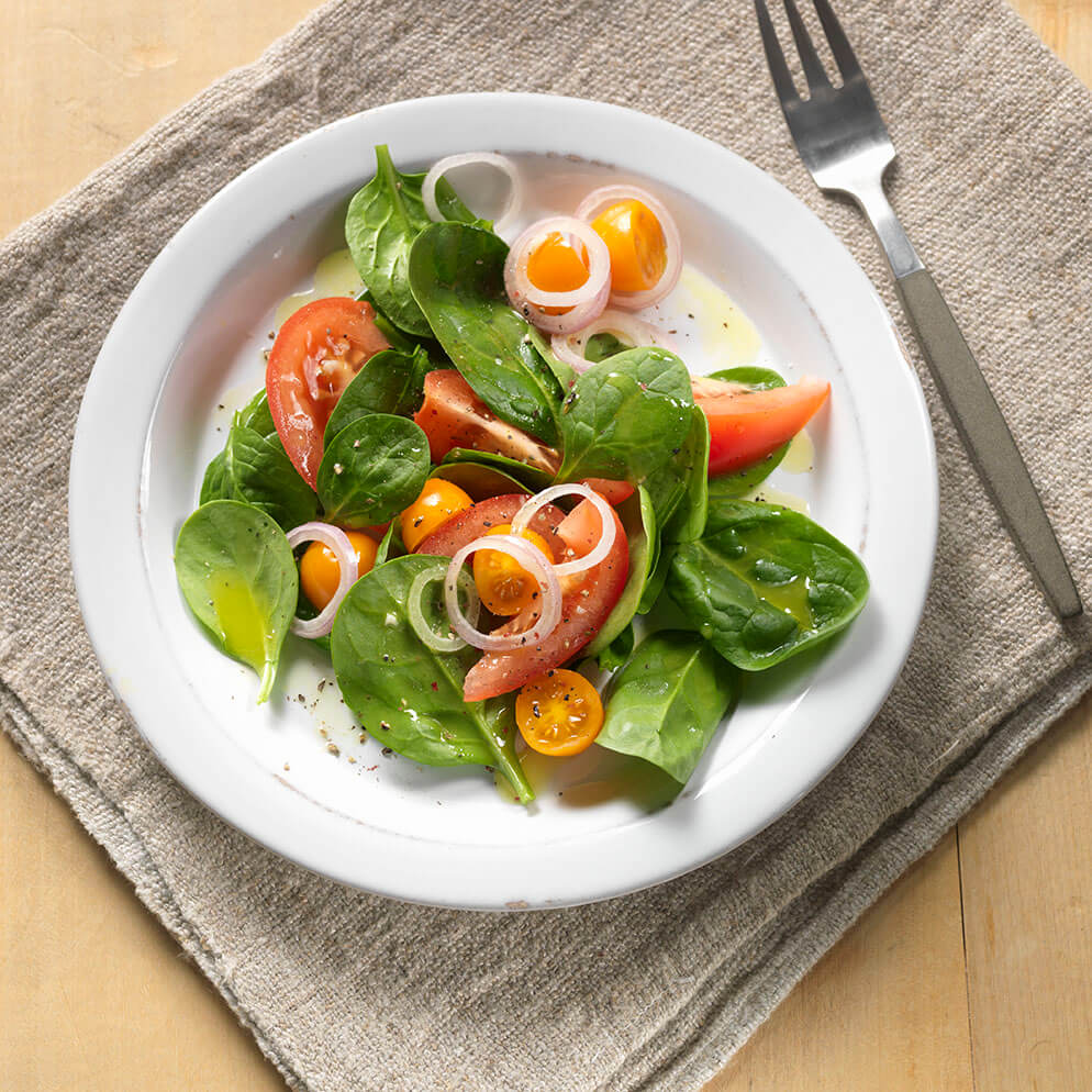  Recette avec du ReaLime : Salade de tomates avec vinaigrette au miel et à la lime dans une assiette 